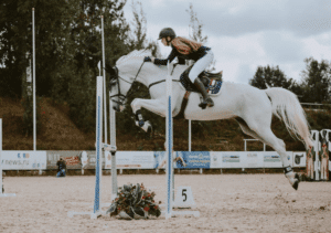 a young girl riding a horse competitively