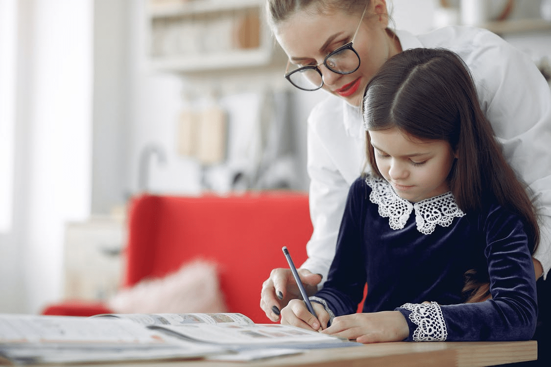 A student taking an online class under the supervision of her parent