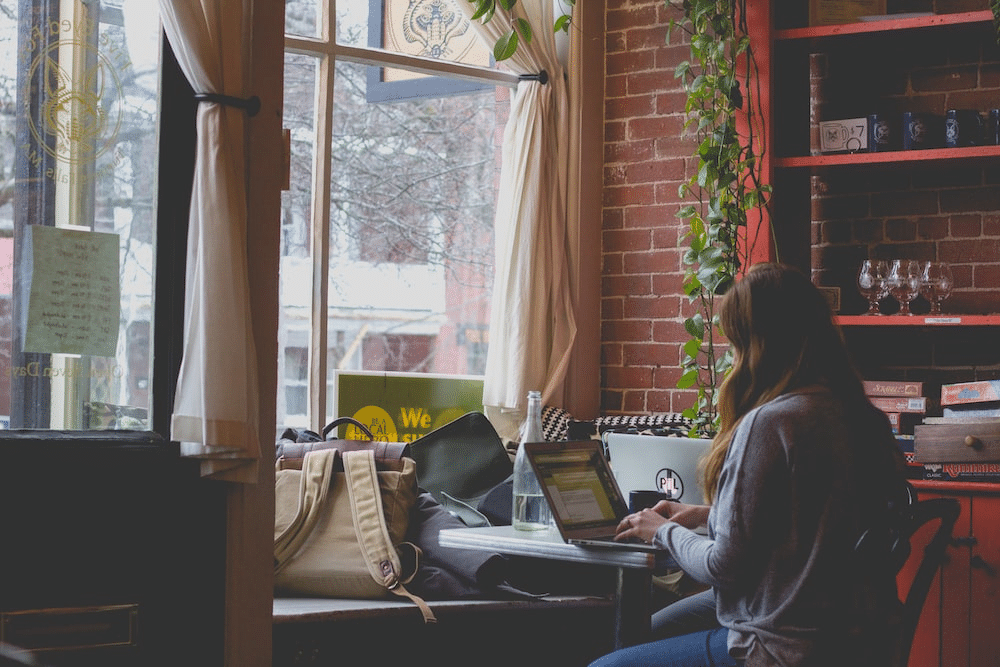 a student attending online school at a local coffee shop