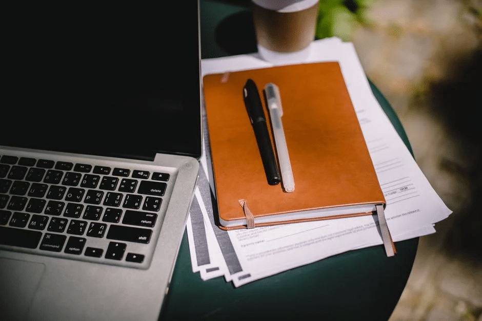 A laptop and notebook in preparation for an online class in the UK