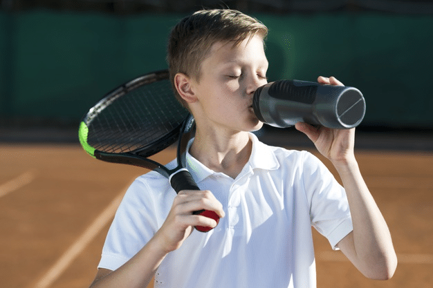 a boy playing tennis after attending online classes