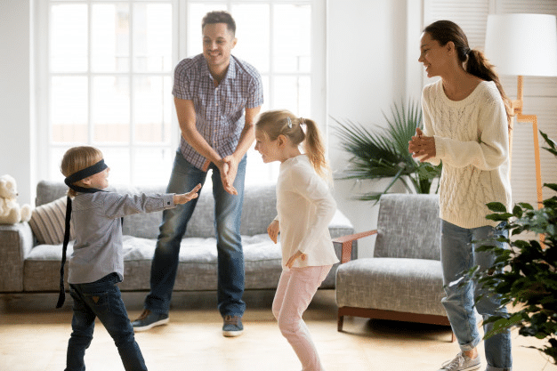 a family of four playing in the living room