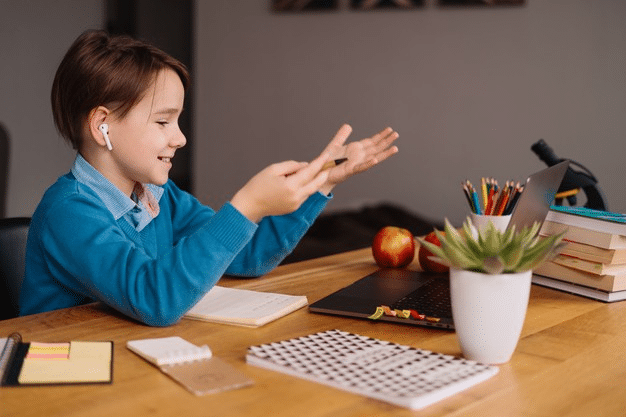 a young boy animatedly speaking with his teacher and peers