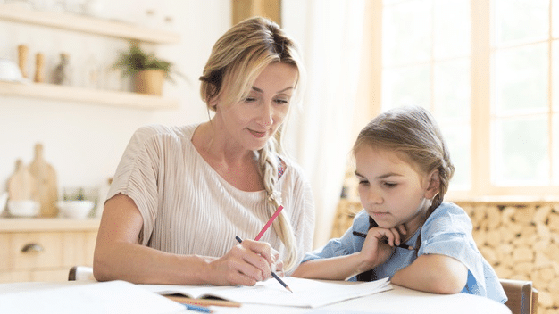 a young girl working on her SPAG homework with her mom