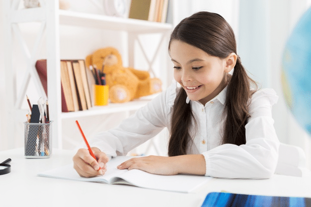 a young girl writing in a notebook