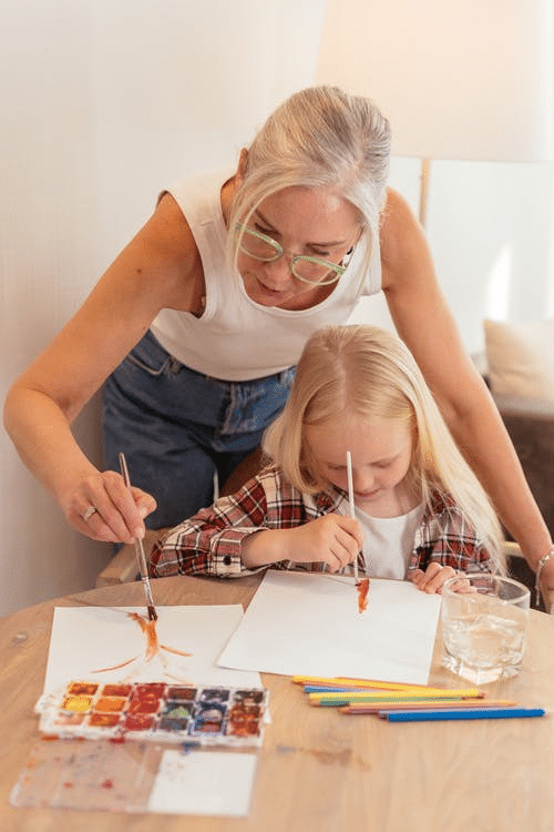 a grandparent helping her granddaughter with a school activity