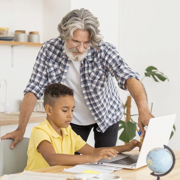 grandfather helping his grandson navigate online school