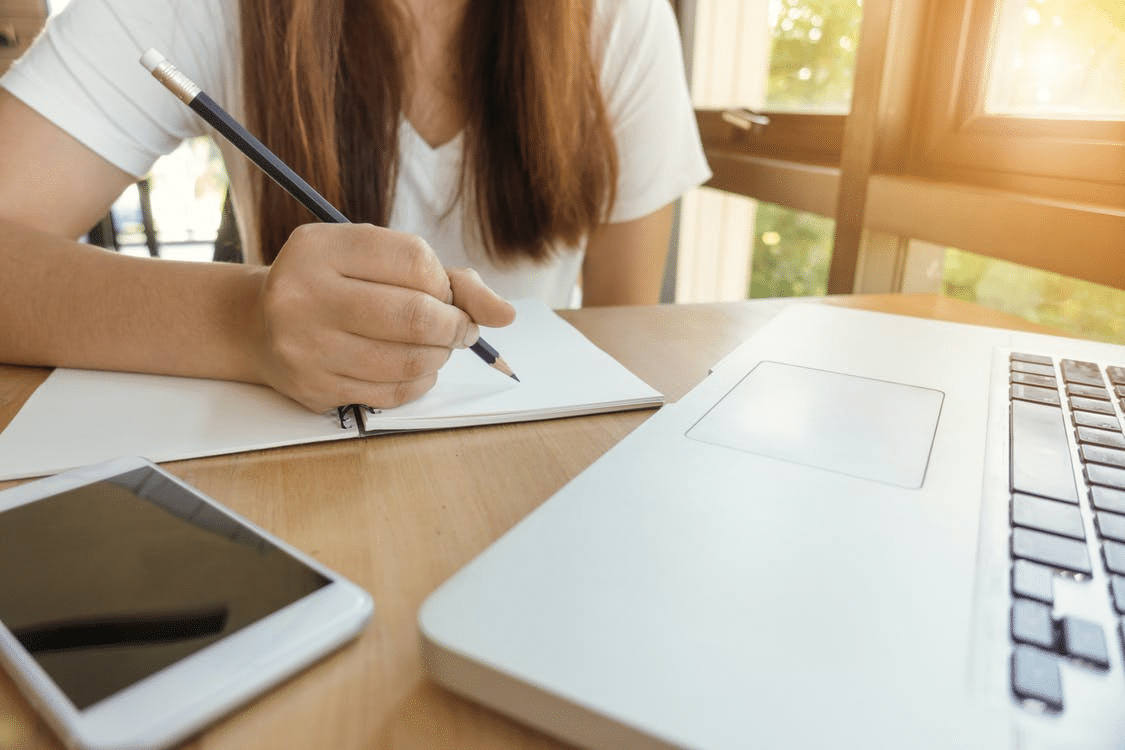 a student taking notes during her online class in Northern Ireland