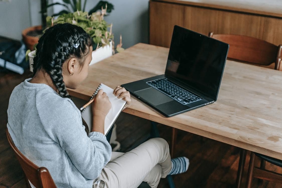 a student consulting her teacher during an online class